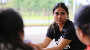 female student in focus sitting outside.